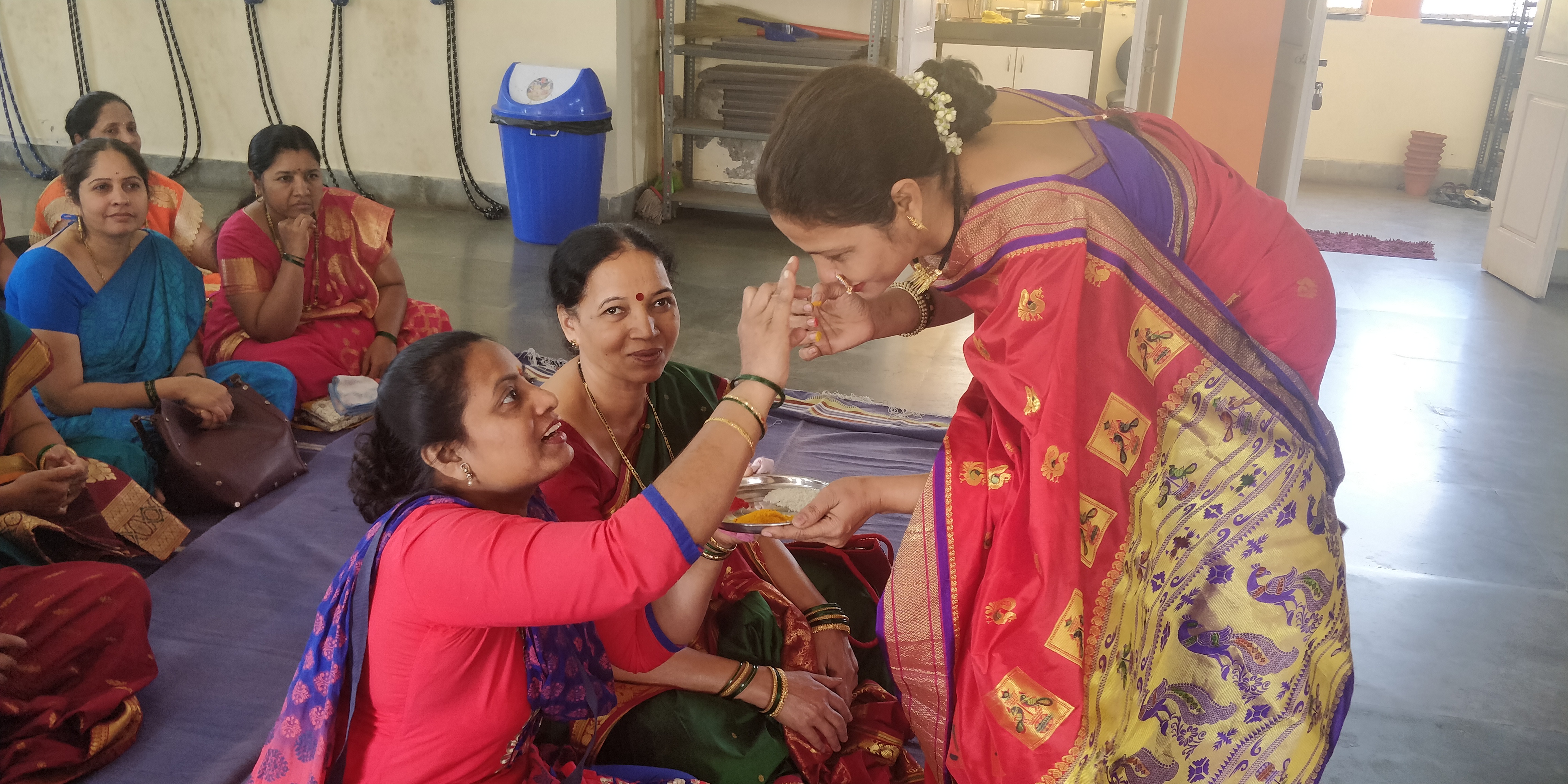 A beneficiary applying 'haldi' and 'kumkum' to the Project Director. A ritual where women bless each other and acknowledge a happy and prosperous married life for each other
