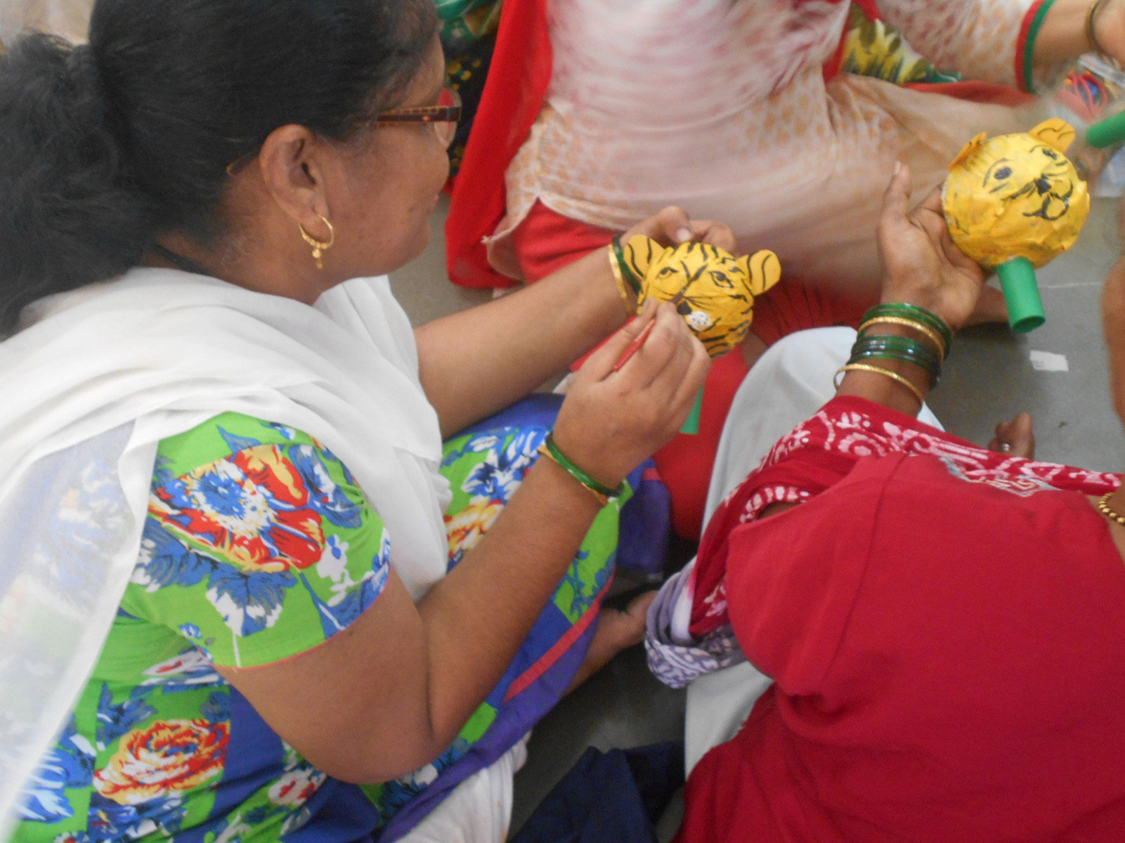 Women busy coloring a puppet

