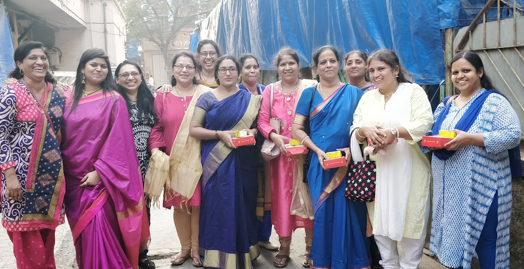 Batch of beneficiaries from Tardeo Hamaara Sapna, staff and teacher smiling into the camera near the centre