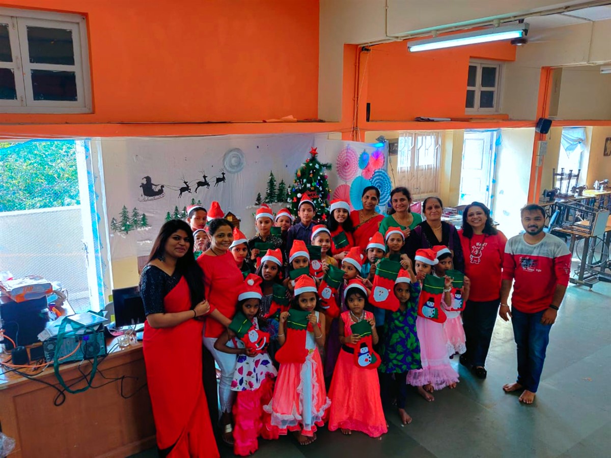 Happy children with their Christmas stocking at the end of the Christmas party with staff and teachers at Hamaara Sapna, Tardeo Centre