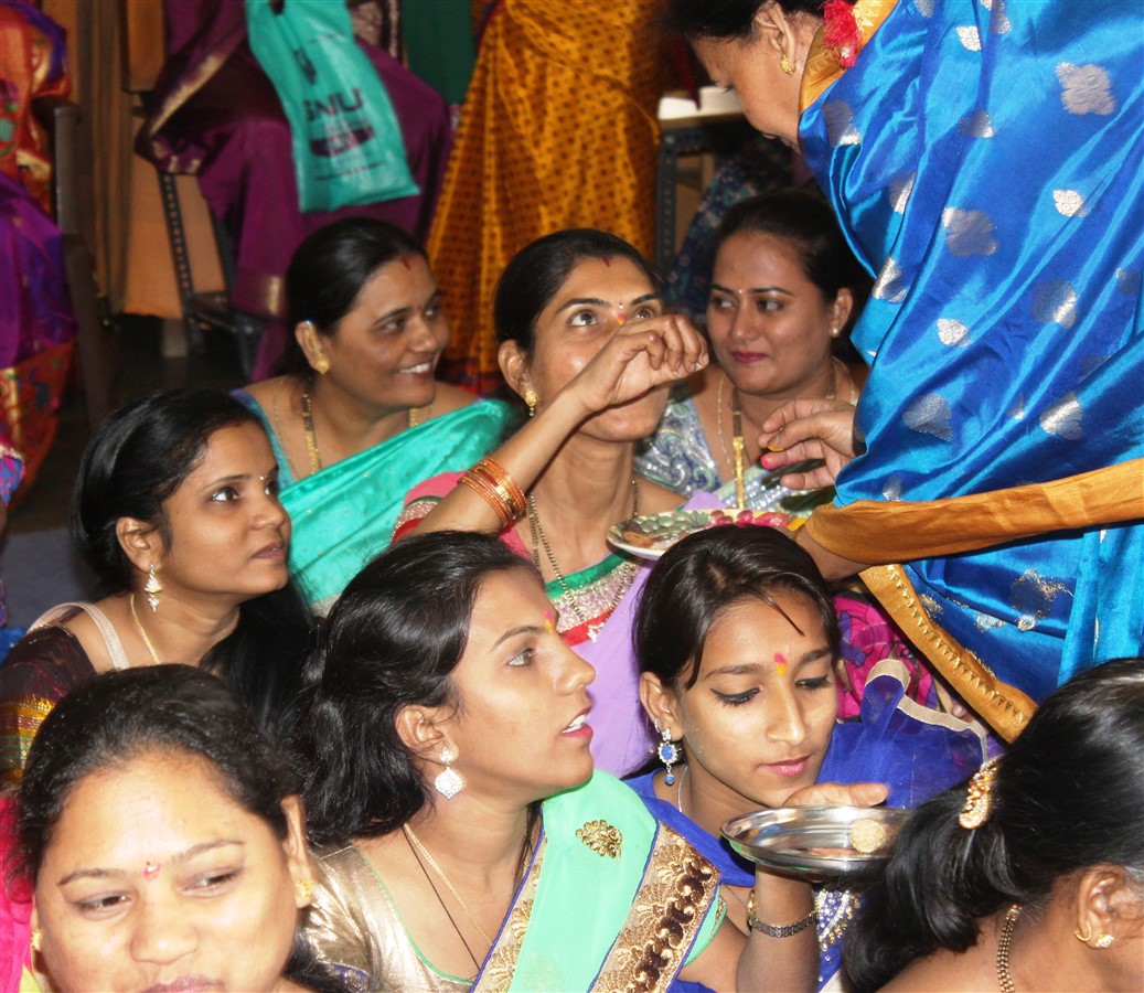 Women performing the Haldi kumkum ceremony on each other
