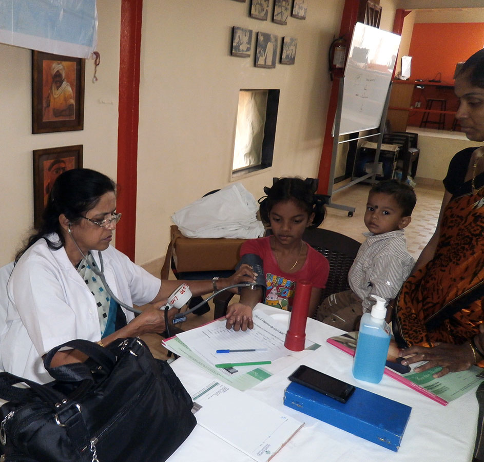 Beneficiary getting her daughter examined at the Medical Camp conducted by Lilavati Hospital (March, 2014)